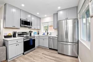 a kitchen with white cabinets and a stainless steel refrigerator at Tower 9 D in Oceanside