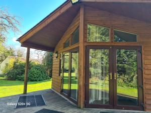 a large glass door on a wooden house at The Reading whole chalet with lake and two acre gardens in Reading