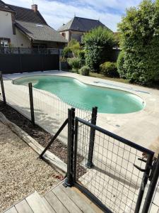 ein kleiner Pool in einem Garten mit einem Zaun in der Unterkunft Gîte Les Rouffy in Saint-Mard-lès-Rouffy