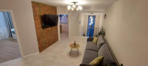 a living room with a couch and a tv on a wall at Matei Apartments in Baia Mare