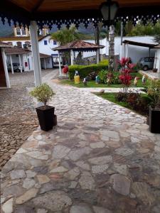 a stone walkway with potted plants on a patio at Hotel Ponta do Morro in Tiradentes