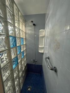 a bathroom with a shower with a blue tile wall at Residencial Alcanar Costa in Alcanar