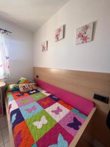 a bedroom with a bed with a colorful quilt on it at Residencial Alcanar Costa in Alcanar +16 photos