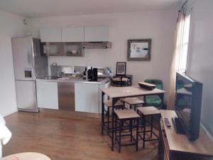 a kitchen with a table and chairs and a refrigerator at Appartement coeur de Saint-Tropez in Saint-Tropez