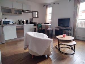 a living room with a table and chairs and a kitchen at Appartement coeur de Saint-Tropez in Saint-Tropez