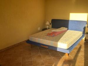 イーゾラ・ロッサにあるResidenze confort Isola Rossaのベッドルーム1室(ブルーヘッドボード付きのベッド1台付)
