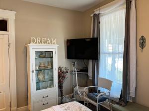 a room with a tv and a hutch with a window at Historic Branson Hotel - Quiet Quilt Room with King Bed - Downtown - FREE TICKETS INCLUDED in Branson
