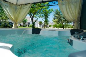 uma piscina com mesa e cadeiras na água em B&B Trulli Donna Isabella em Locorotondo