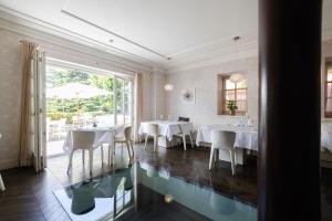 un restaurante con mesas y sillas y suelo de cristal en Hotel Eden en Sistiana