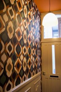 a hallway with a patterned wall next to a door at Drostenstraat 5 in Zwolle