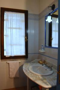 łazienka z umywalką i oknem w obiekcie villa aurora w mieście Villasimius