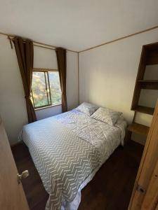 Habitación pequeña con cama y ventana en El Chiflon Un Lugar de Ensueño en 