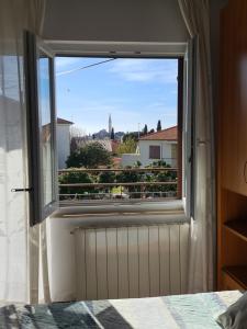ein Fenster in einem Schlafzimmer mit Blick auf einen Balkon in der Unterkunft Apartments Ada in Rovinj