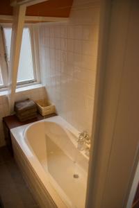 a bath tub in a bathroom with a window at Drostenstraat 5 in Zwolle