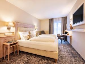 a hotel room with a bed and a television at Landgasthof Hotel Gentner in Nürnberg