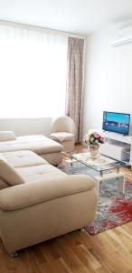 uma sala de estar com um sofá e uma mesa em Apartman A1 em Bijeljina