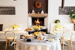 a table with food on it with a fireplace at Hotel Eden in Sistiana