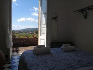 a bedroom with a bed and a large window at Saja Country House in Acireale