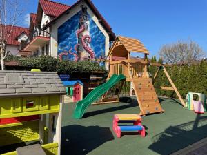 a playground in front of a house with a slide at Dafne 2 in Niechorze