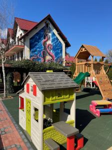 a toy house with a playground in front of a house at Dafne 2 in Niechorze +11 photos