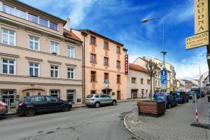 een stadsstraat met auto's op straat bij Hotel Palace in Pilsen