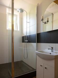 een badkamer met een douche en een wastafel bij Świerkowe Przysiółki in Sośnina