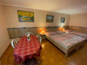 um quarto com duas camas e duas mesas em Hajnal Apartman em Hajdúszoboszló