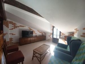 sala de estar con sofá y TV en El Laberinto, en Sotillo de la Adrada