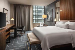 a hotel room with a large bed and a desk at The Westin St. Louis in Saint Louis