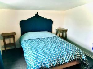 a bedroom with a bed with a blue bedspread and two tables at le dépot Appartement du canal 80m2 à champvert in Champvert