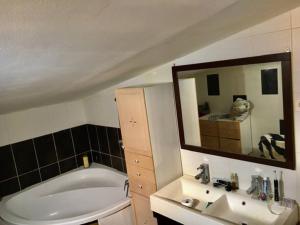 a bathroom with a tub and a sink and a mirror at le dépot Appartement du canal 80m2 à champvert in Champvert +15 photos
