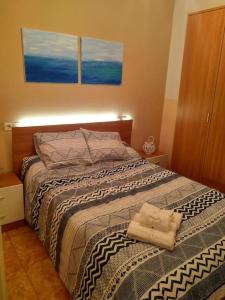 1 dormitorio con 1 cama con 2 toallas en La casita de colores, en Elche