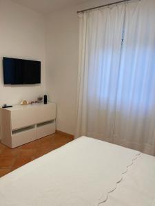 a white room with a television and a white bed at Da Ksenia in Ceglie Messapica