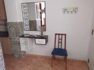 a mirror and a chair in a room at La casita de colores in Elche