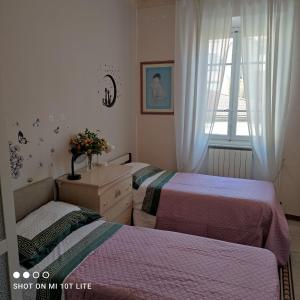 een slaapkamer met 2 bedden, een wastafel en een raam bij tita's house in Lucca