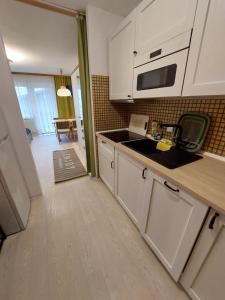 a kitchen with white cabinets and a microwave at Ferienwohnung 6 Bergblick in Sankt Gilgen