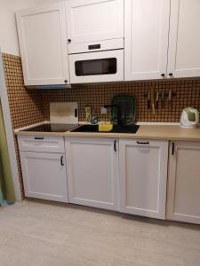 a kitchen with white cabinets and a microwave at Ferienwohnung 6 Bergblick in Sankt Gilgen