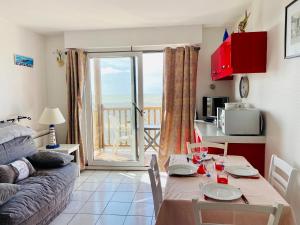 sala de estar con mesa y cocina con balcón en La mer qu’on voit danser…., en Cayeux-sur-Mer