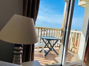 una lámpara y una mesa en un balcón con vistas en La mer qu’on voit danser…. en Cayeux-sur-Mer