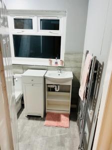a small bathroom with a sink and a window at CozyComfy Apartment Leicester in Leicester
