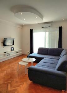 马卡尔斯卡Apartmani Makarska的客厅里有一张蓝色的沙发和一张桌子