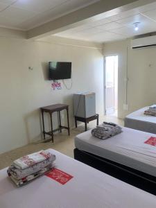 um quarto com 2 camas e uma televisão de ecrã plano em Hotel BELCENTRO em Belém