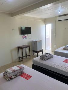 a room with two beds and a flat screen tv at Hotel BELCENTRO in Belém