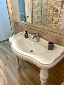 a white sink in a bathroom with a mirror at NEWHOUSE ROOFTOP in Nettuno