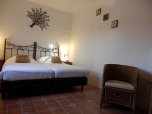 a bedroom with two beds and a chair at B&B Casa Agradable in Arenas