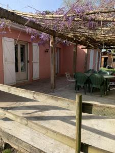 a patio with a table and chairs and purple flowers at Lapeyre in Lignan-de-Bazas
