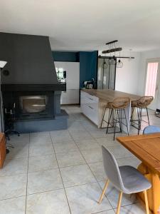 a kitchen with a fireplace and a table and chairs at Lapeyre in Lignan-de-Bazas
