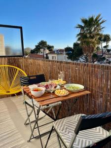 een tafel met kommen eten op een patio bij Beautiful Apartment 200m from Beach in Canet-en-Roussillon