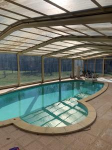 a large swimming pool in a building with an open ceiling at Lapeyre in Lignan-de-Bazas