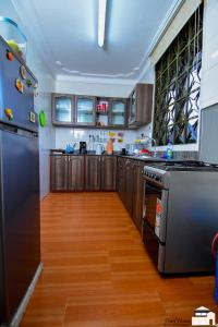 a kitchen with wooden floors and stainless steel appliances at Elegant 2bedroom apartments close to city center in Kampala